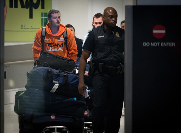 Jack Conger and Gunnar Bentz are escorted by police through Miami International airport after returning to the U.S. (Angel Valentin / AFP/Getty Images)