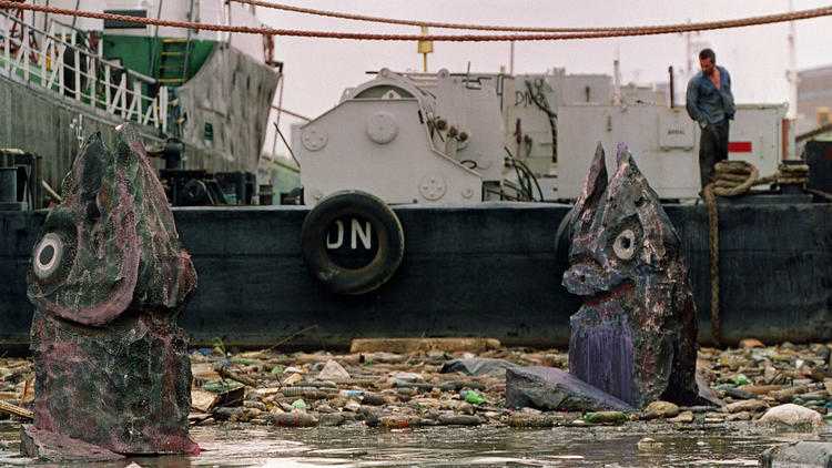 Giant fish sculptures float through garbage in the Riachuelo River as part of a Greenpeace campaign to raise awareness about pollution in the Buenos Aires waterway in 2000.