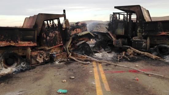 The burned-out husks of heavy trucks sit on Highway 1806 near Cannon Ball, N.D.
