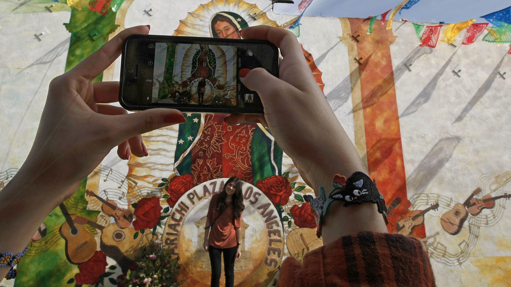 Jessica Alvarez takes a photo of Briana Alvarez on a visit to Mariachi Plaza in Boyle Heights.