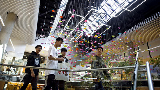 People walk past paper butterflies hanging inside the Westfield Santa Anita shopping mall on Friday,