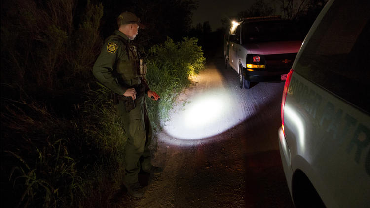 Border Patrol Agent Richard Schweitzer keeps an eye on migrants who had just illegally crossed the R