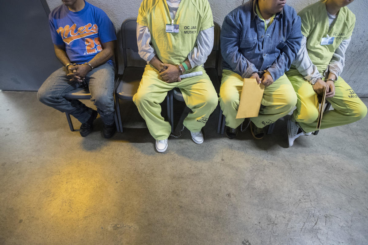 Sergio Rodriguez, trái, ngồi cùng những khác trên ghế khi đang đợi phán quyết tại trụ sở ICE ở Los Angeles. 