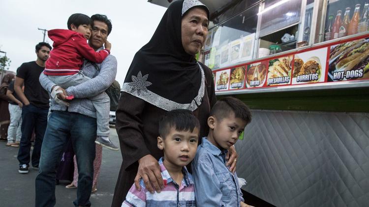 Families wait in line at the taco truck in the parking lot of the Islamic Center of Santa Ana.