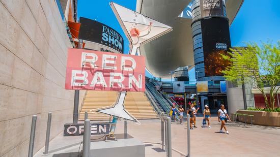 Vegas visitors walk past the Red Barn sign that has gone up outside Fashion Show Mall. While it bega
