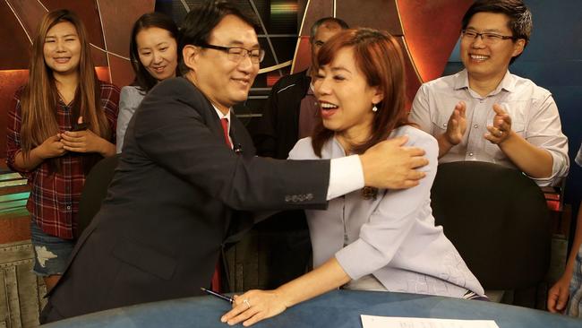 Harry Chang hugs his co-anchor Christine Chiang after their final broadcast Friday.
