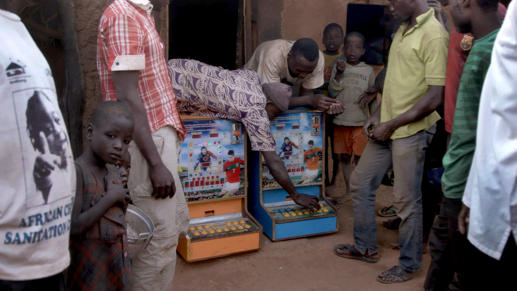 Villagers bring two gambling machines out from a hut in Zamashegu, in Ghana's Northern Region.