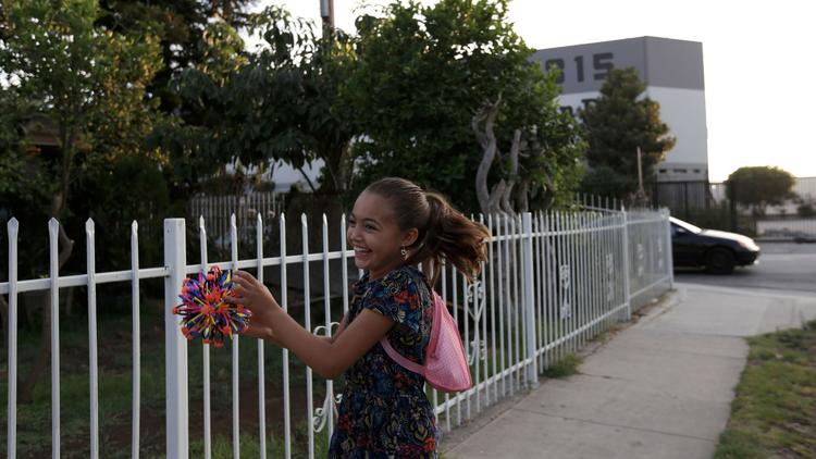Bella Marquez, 8, plays catch across the street from Maywood L’Chaim, the second business that was a