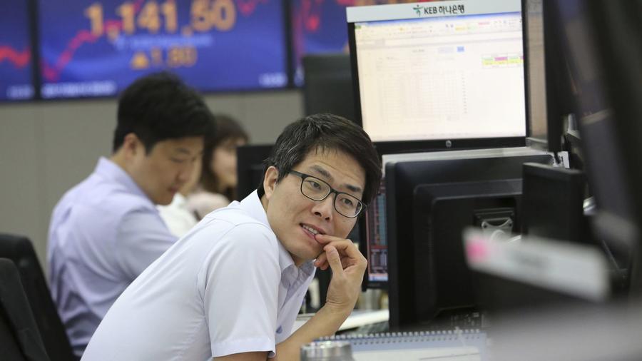 A currency trader watches monitors at the foreign exchange dealing room of the KEB Hana Bank headqua