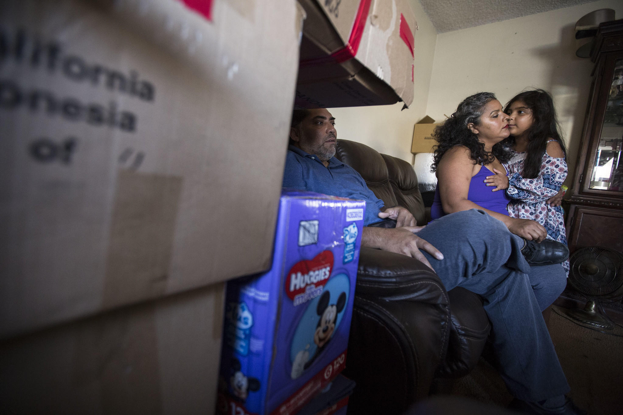 Ricardo Madrigal and his wife, Maria Barrancas, and their daughter Luz, 6, relax in their apartment after packing up their belongings.