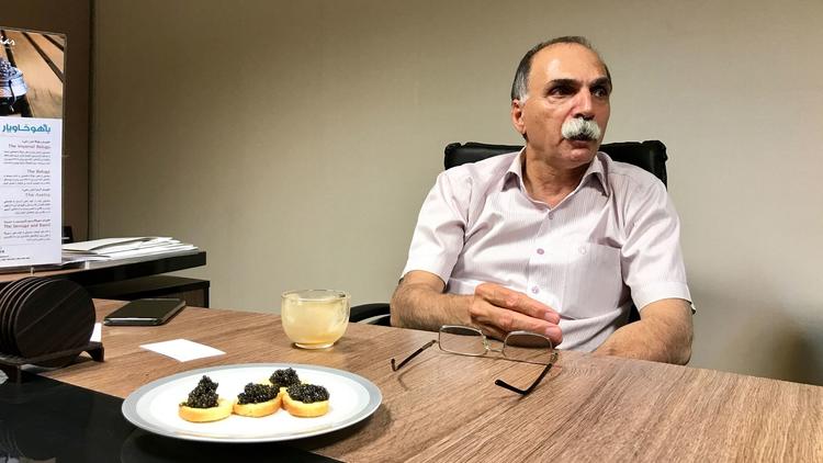 Nasser Meshkin Azarian, chairman of Bahoo Caviar, shares a plate of Iranian beluga caviar in his Teh