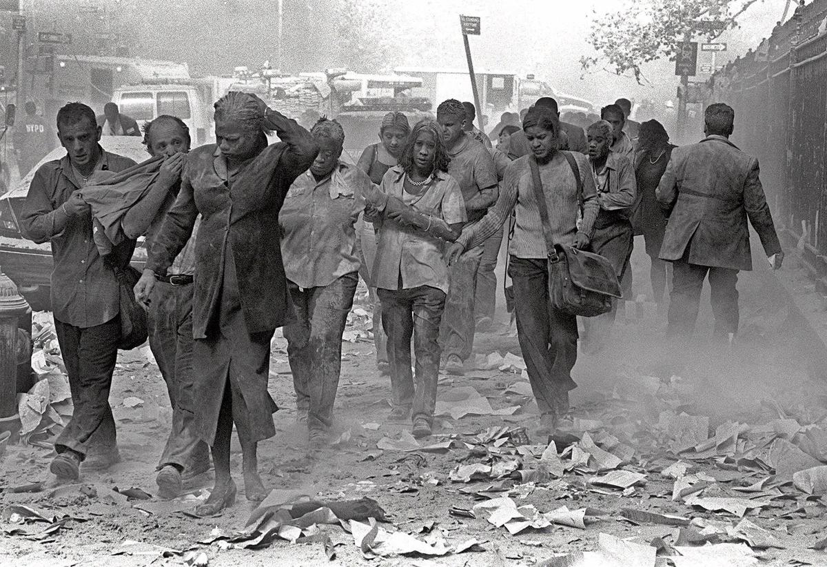 People covered in dust walk over debris near the World Trade Center in New York.