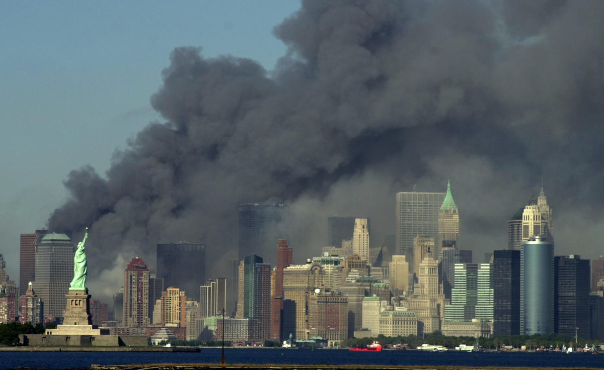 Thick smoke billows behind the Statue of Liberty from where the towers once stood.
