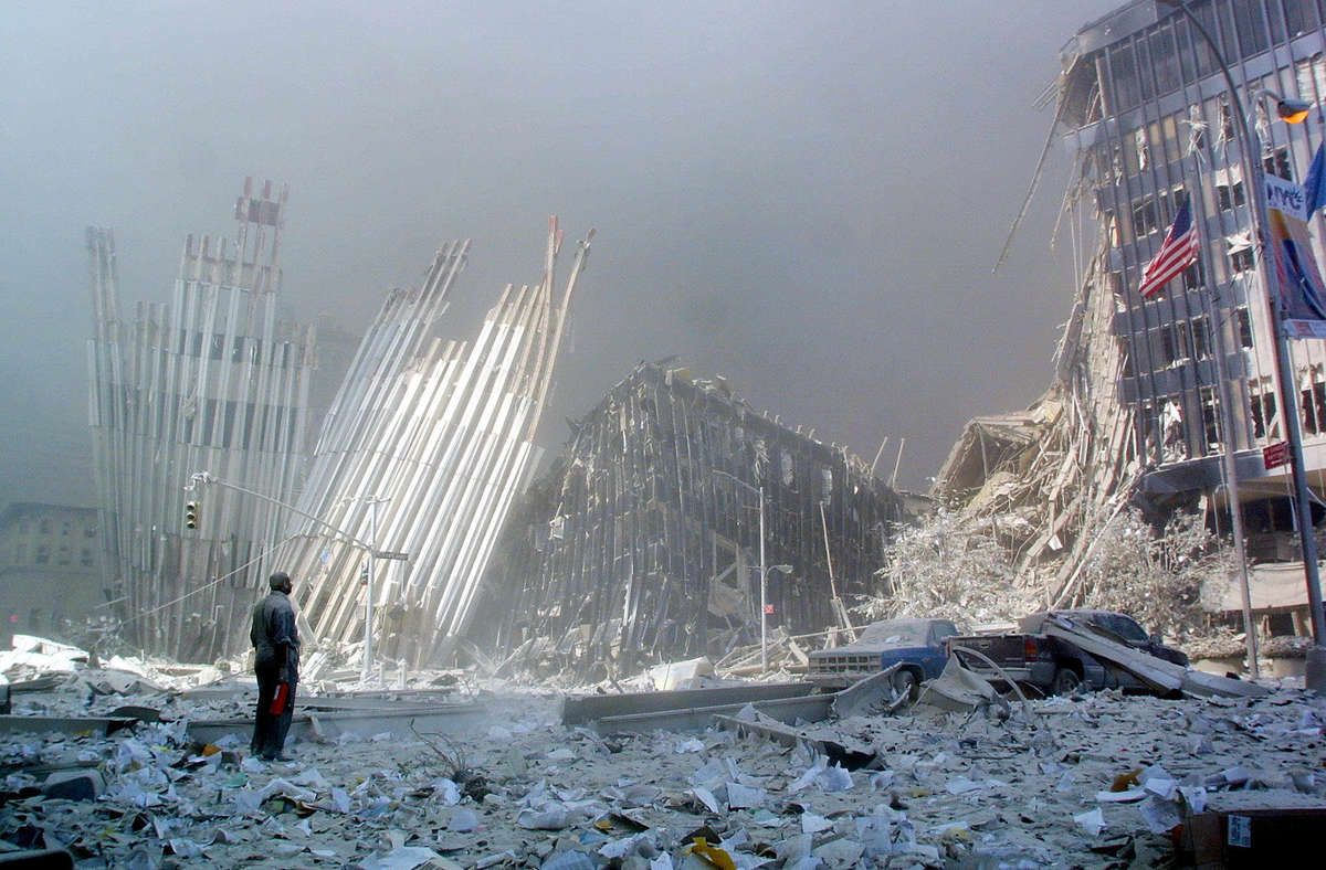 A man stands in the rubble of the World Trade Center and calls out, asking if anyone needs help,