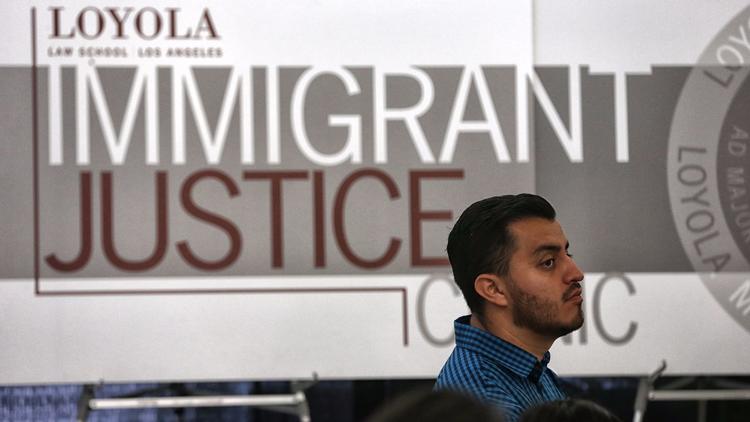 Christian Perez, 30, consults with volunteers at the Loyola Immigrant Justice Clinic at Loyola Law S