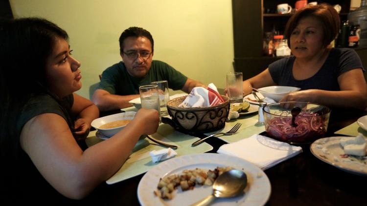 Brenda Soriano, left, converses with her parents Bertha Martinez and Victor Soriano during dinner in