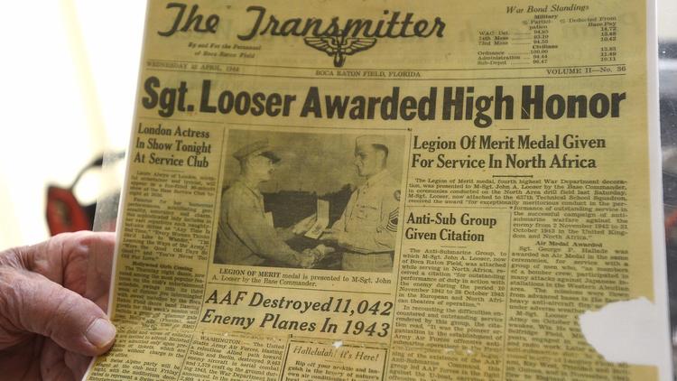 Veteran John Looser shows a newspaper clipping from when he was awarded the prestigious Legion of Me