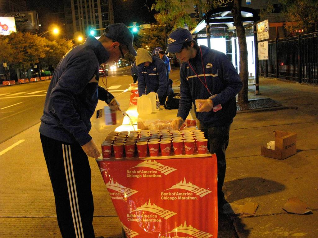 Russell Karas, 16, left, and Robert Perez, 17, right, both of Lombard, prepare a table of water for runners in the Bank of American Chicago Marathon on North LaSalle Street between West Ontario Street and West Erie Street