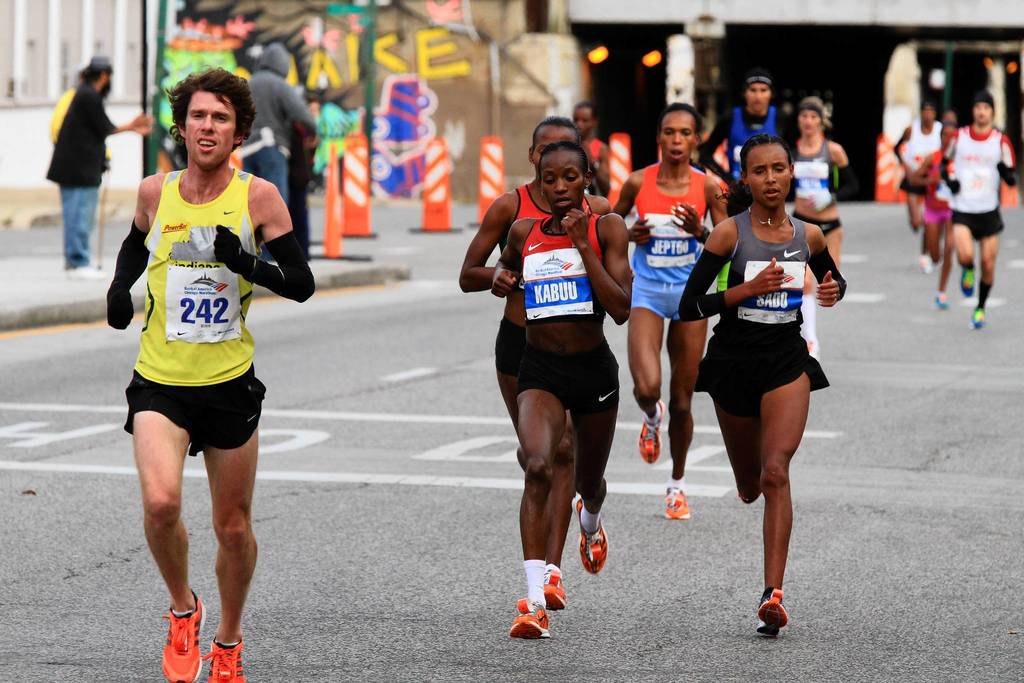 Lucy Kabuu, of Kenya, left center, and Fatuma Sado, of Ethiopia, right center, are neck-and-neck as they head through Chicago's Pilsen neighborhood during the Bank of America Chicago Marathon.