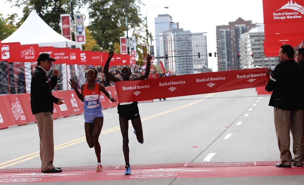 Ethiopian Atsede Baysa, right, narrowly edges out her competitor, Kenya's Rita Jeptoo, to win the 2012 Bank of America Chicago Marathon in a time of 2 hours 22 minutes 3 seconds.
