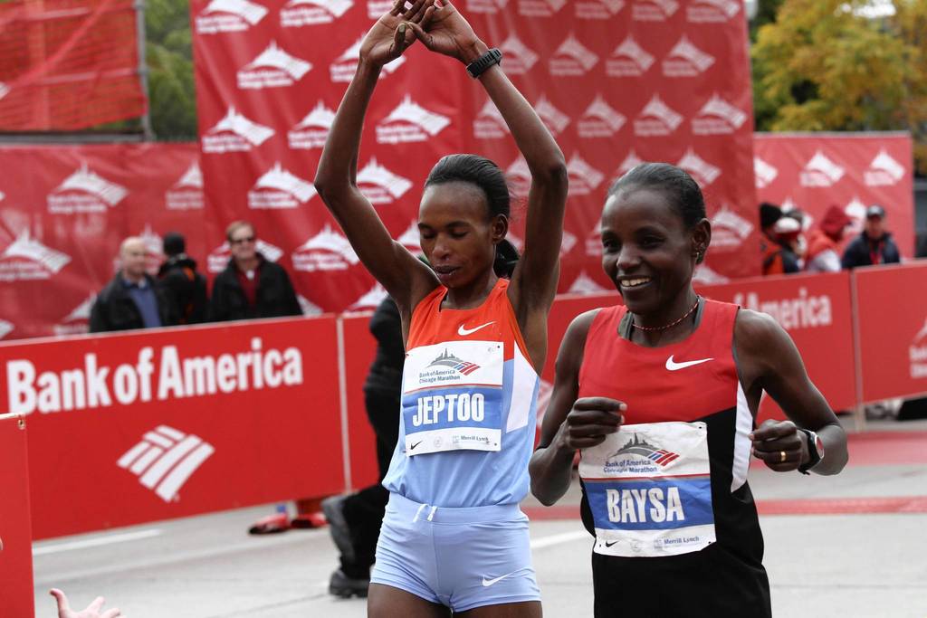 Ethiopian Atsede Baysa, right, narrowly edges out her competitor, Kenya's Rita Jeptoo, to win the 2012 Bank of America Chicago Marathon in a time of 2 hours 22 minutes 3 seconds.