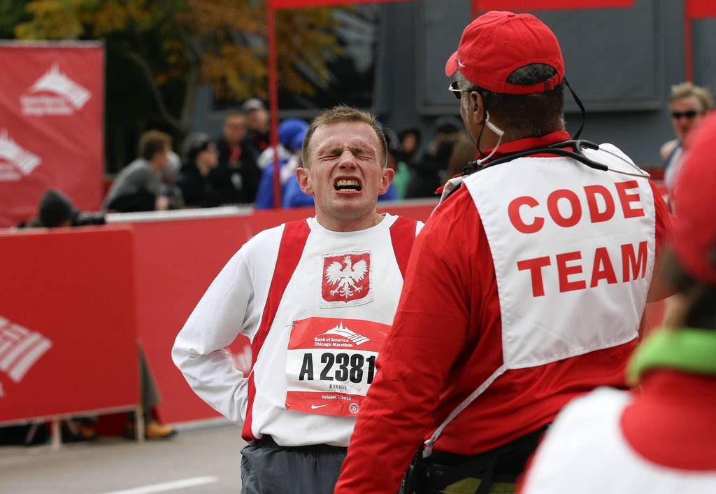 A runner suffering from leg pain crosses the finish line on Columbus Drive at the Bank of America Chicago Marathon.