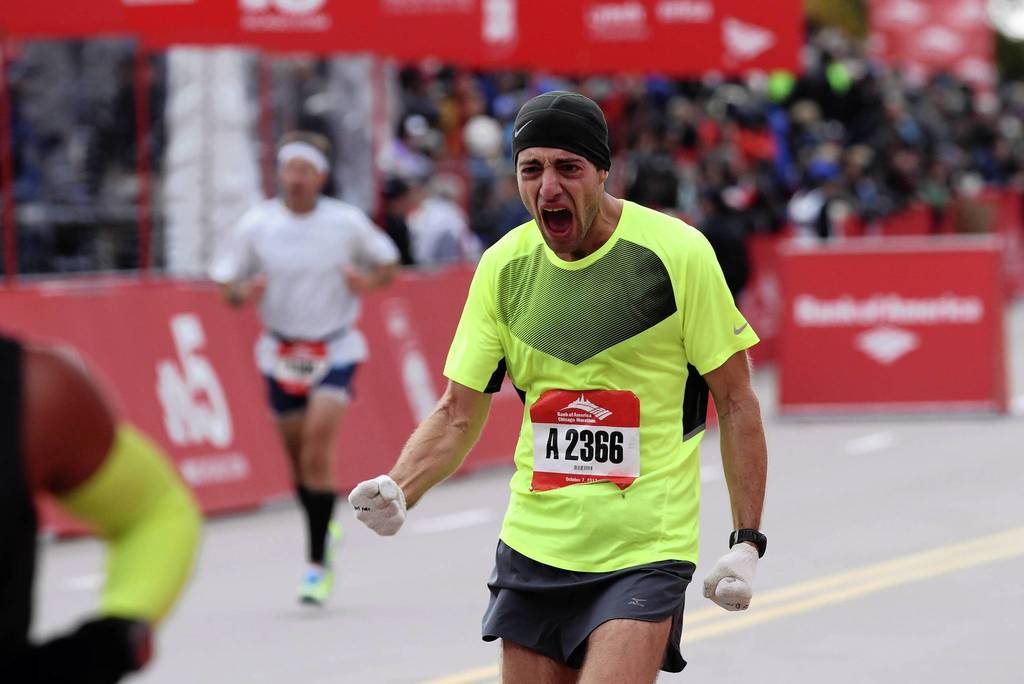 A runner celebrates crossing the finish line at the Bank of America Chicago Marathon.