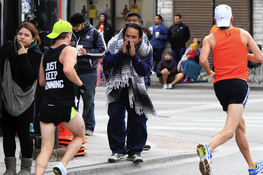 The streets of the Pilsen neighborhood in Chicago are filled with runners and cheering spectators, like Leo Ramirez, at mile 19 of the Bank of America Chicago Marathon.
