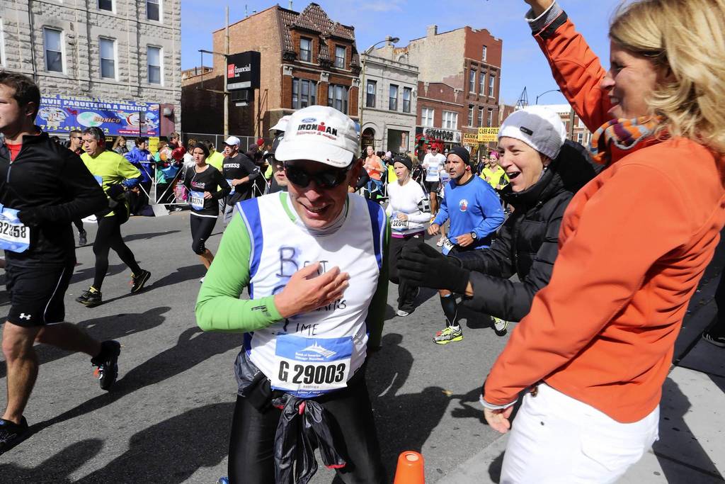 Jack Crowe gets encouragement from his wife, Ave Zuccarino, of Oak Park, as he makes his way through the Pilsen neighborhood during the Chicago Marathon.