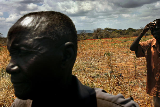 James Mukunga, left, has dealt with years of drought-ruined crops on the small farm he shares  with his wife and 12 children in eastern Kenya, about 200 miles from the refugee camps. The family chopped down their few remaining trees to make charcoal to sell. (Rick Loomis / Los Angeles Times)