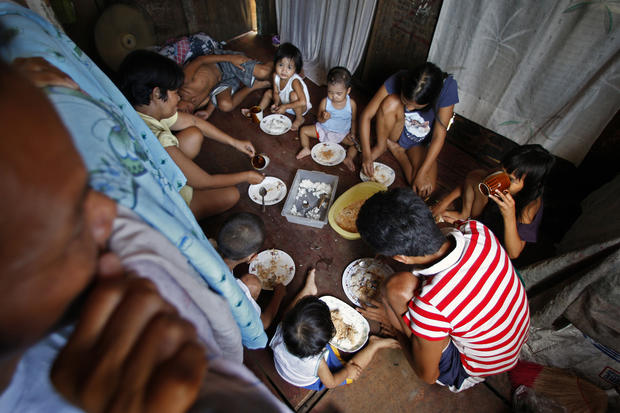 The Naz family gathers for a meal, in the same room where everyone sleeps. When food is especially scarce, only the children eat. About a third of Manila's residents live in poverty. (Rick Loomis / Los Angeles Times)