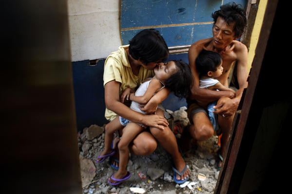 Yolanda and Noel sit in the alley outside their shack with two of their children. They scramble each day to get the money to feed the family. Although she is a Roman Catholic, Yolanda disagrees with the church's opposition to contraception and is part of a lawsuit challenging the city ban on providing birth control at public clinics. (Rick Loomis / Los Angeles Times)