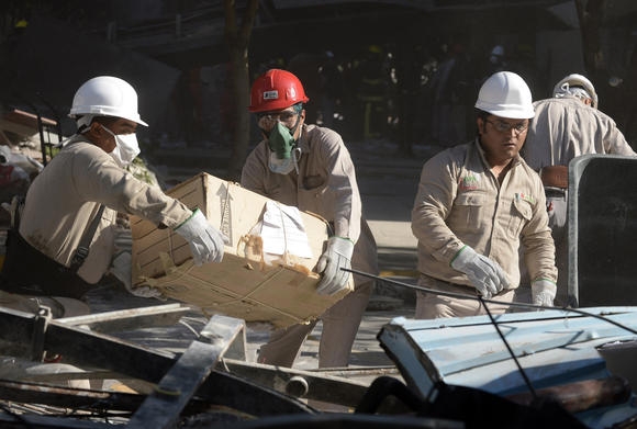 Pemex workers remove items from the headquarters of the state-owned Mexican oil company in Mexico City on Friday after an explosion the day before. (Alfredo Estrella / AFP/ Getty Images / February 1, 2013)