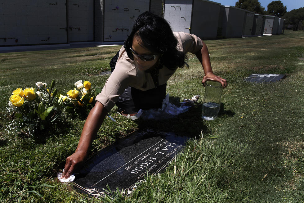 LaQuita Suggs cleans her mother's headstone at the Inglewood Park Cemetery on the seventh anniversary of her death.