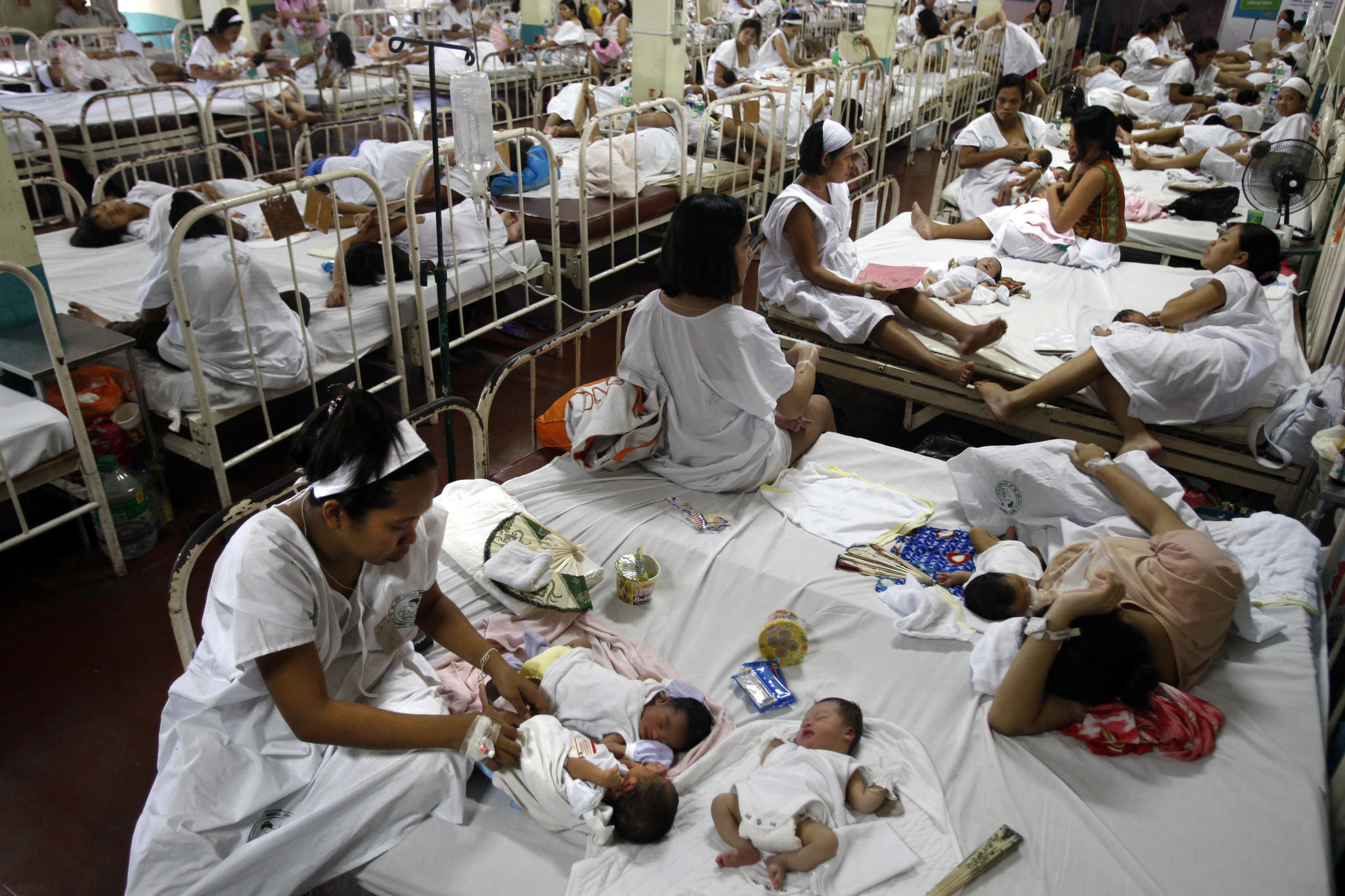 Women share beds after giving birth at Dr. Jose Fabella Memorial Hospital in Manila. The Philippine capital is one of the most densely populated places on Earth. A ban on contraception at public clinics there has put birth control out of the reach of most of the city's poor. (Rick Loomis / Los Angeles Times)