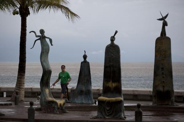 A man walks his dog in Puerto Vallarta, after Patricia mostly missed the Mexican tourist town. (Associated Press)