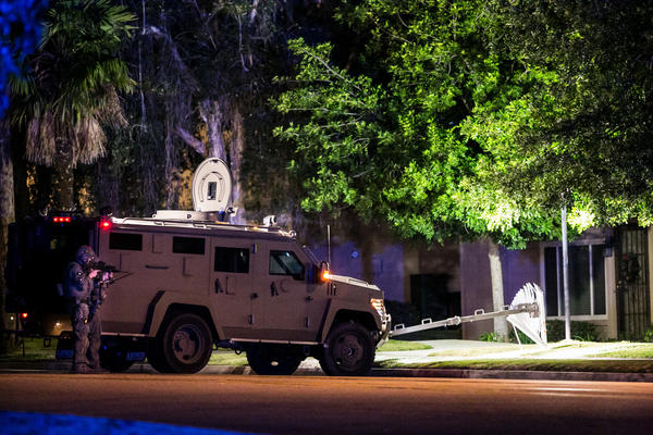A SWAT team outside a residence in Redlands on Wednesday night. (Marcus Yam / Los Angeles Times)