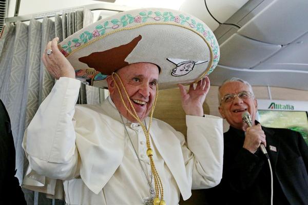 Pope Francis dons a sombrero he received from a Mexican journalist aboard the plane to Cuba and Mexico. (Alessandro Di Meo / Pool Photo)