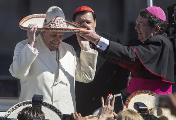 Pope Francis dons a Mexican charro-style sombrero given to him by a person in the crowd in Mexico City's main square, the Zocalo. (Christian Palma / Associated Press)