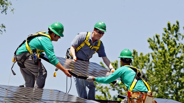 SolarCity workers install panels on a Denver home with Sen. Michael Bennet (D-Colo.), center, in 2010.