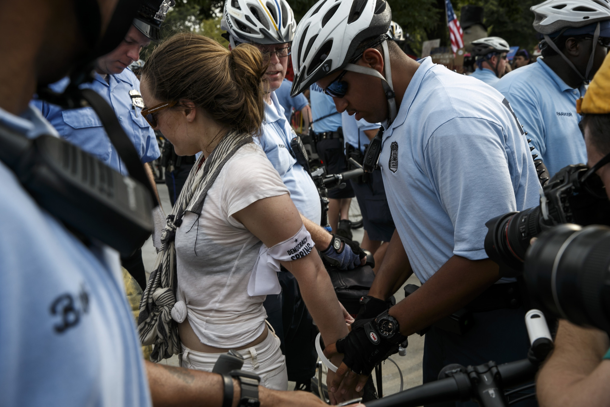 Protesters are detained and cited as they climb past a barrier set up by police at the Democratic National Convention