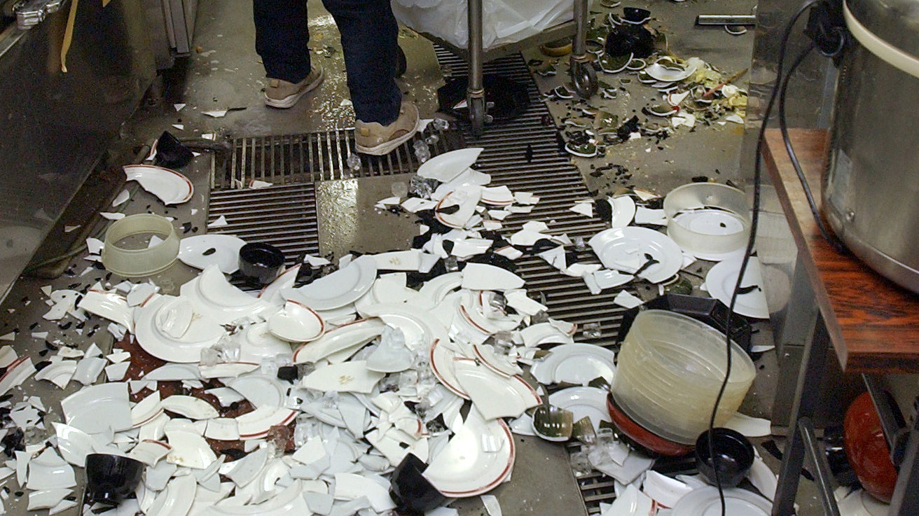 Workers clean up broken dishes at a restaurant in Kushiro, on the northern Japanese island of Hokkaido, after a powerful earthquake on Nov. 29, 2004.