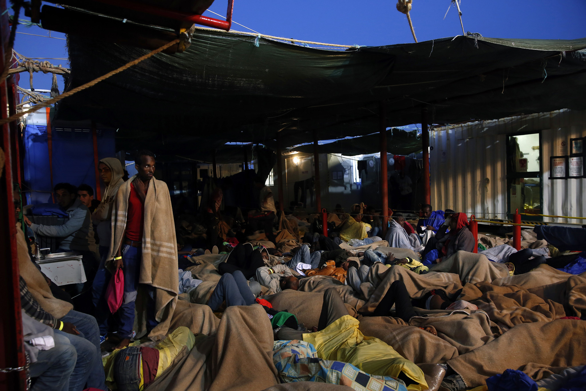 Migrants sleep on the deck of the rescue ship Vos Hestia, operated by Save the Children, as it heads for Sicily. The migrants, of several nationalities, were bound for Europe.