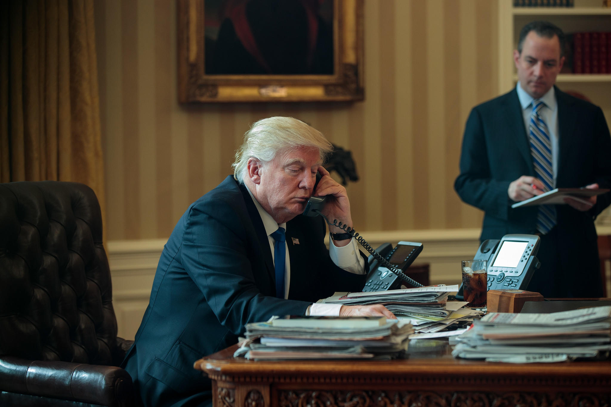 Trump speaks by phone with Putin as White House Chief of Staff Reince Priebus looks on.