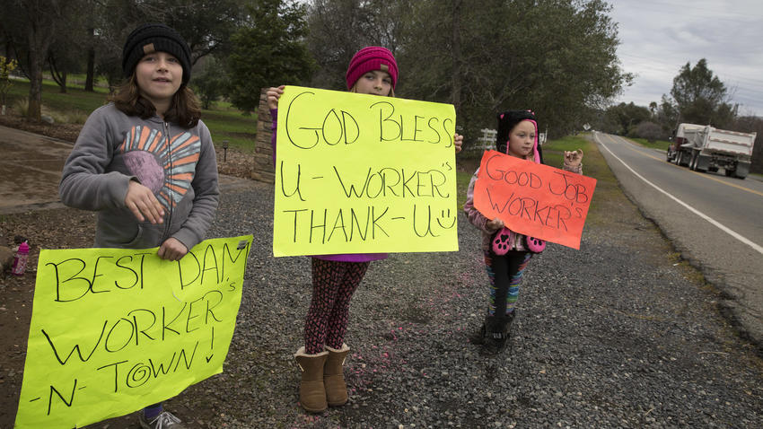 McKenna Harvey, 9, left, Kylie Atteberry, 11, and Brooklyn Atteberry, 7, hold signs thanking workers for the repair efforts at the Oroville Dam. (Brian van der Brug / Los Angeles Time)