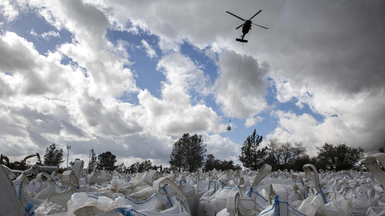 Helicopters ferry sand and rocks from a staging area to the Oroville Dam's emergency spillway repair project. (Brian van der Brug / Los Angeles Times)