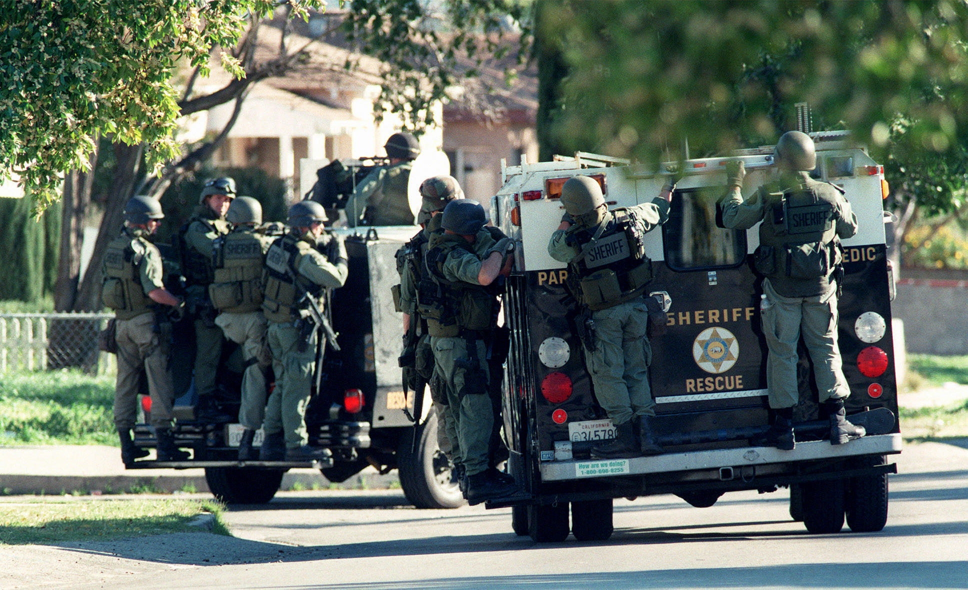 Armored personnel carriers move down Radford Street in a house–by–house search for a suspect.