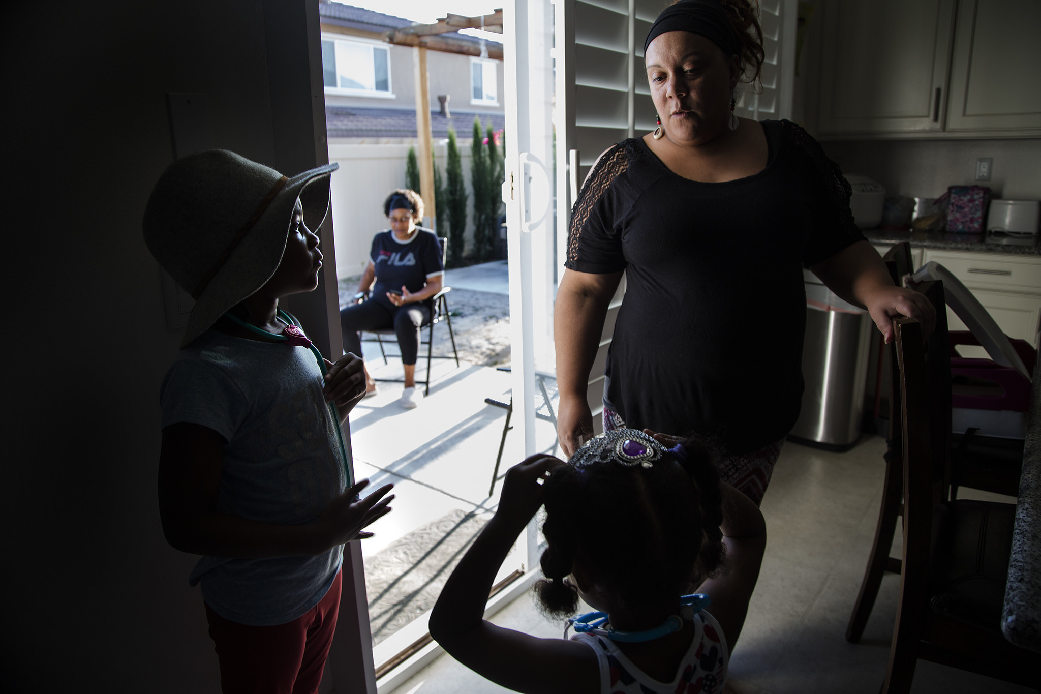 Housing manager Erica Wilson, right, spends time with Leana Wilson, 6, left, and Brooklyn Jackson, 3, before dinner at a transitional home in Eastvale that serves former offenders.