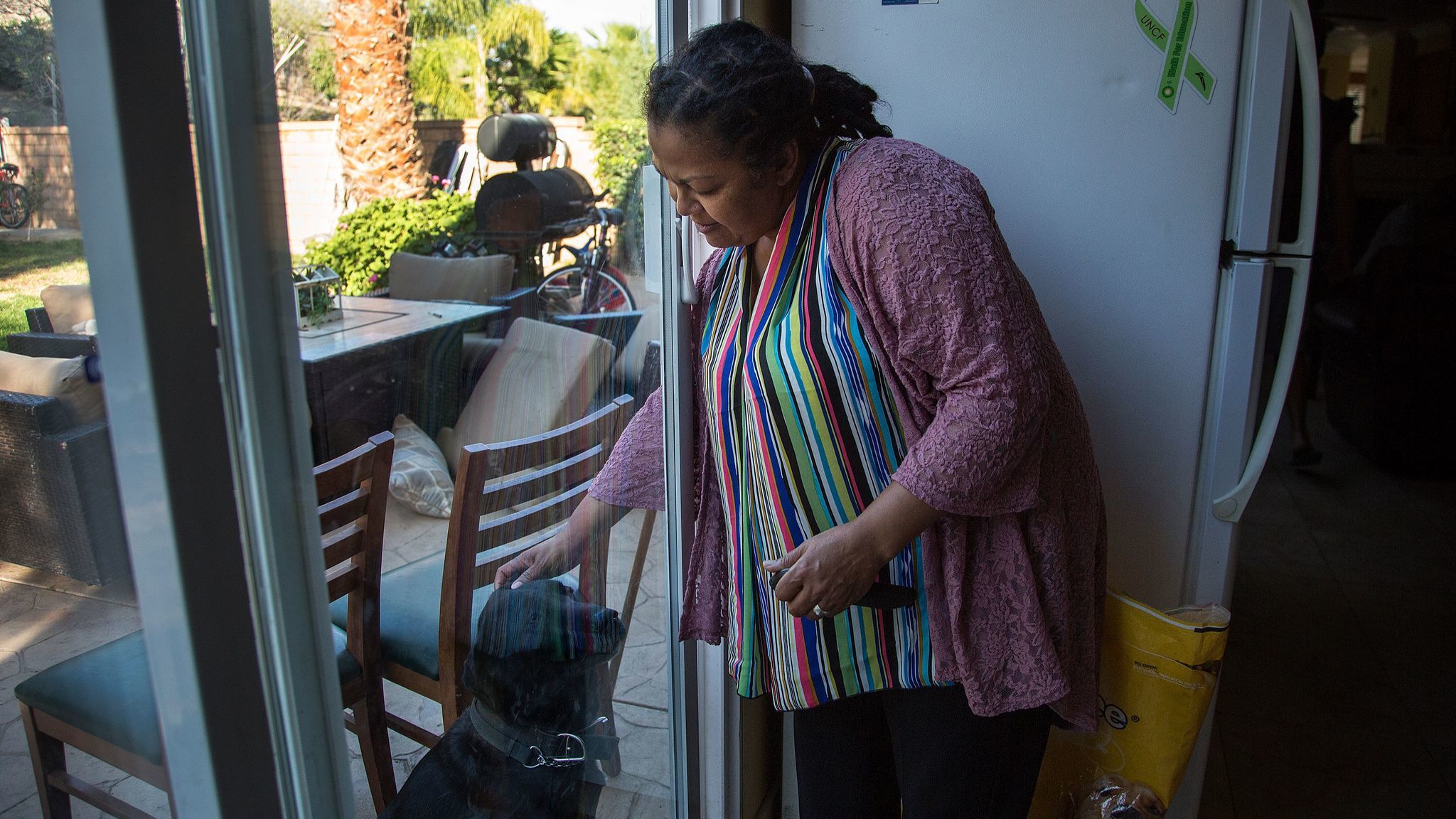 Vonya Quarles, executive director of Starting Over Inc., pets Charlie, a Labrador, at a men's transitional home she runs in Corona. Programs like hers aim to help former inmates reenter society.