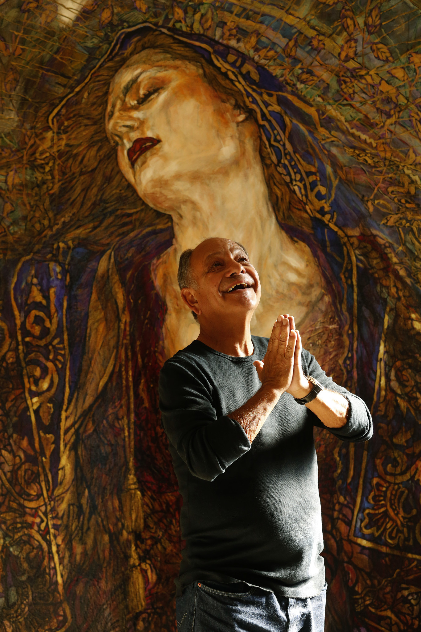 Cheech Marin strikes an angelic pose in front of a painting by Chicano artist George Yepes entitled, "Axis Bold As Love," in his Pacific Palisades home on March 27.